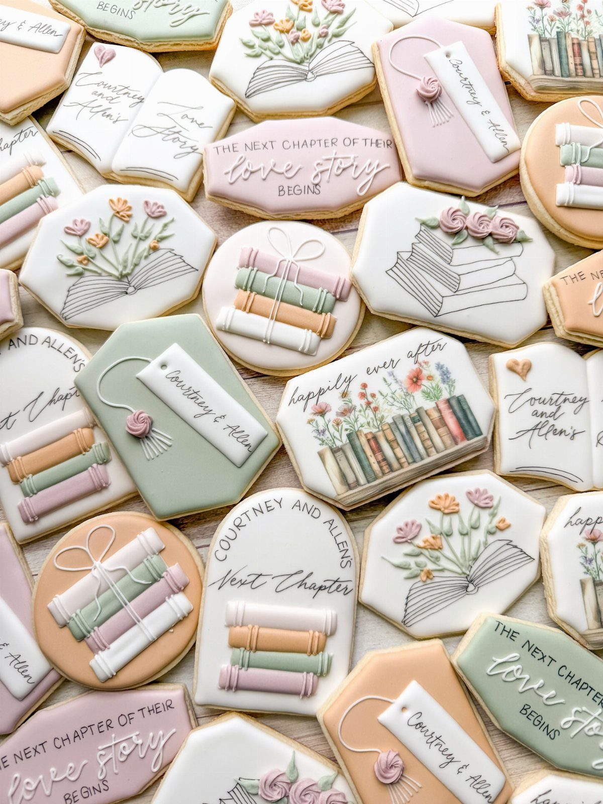 Decorated sugar cookies shaped like books and bookmarks with floral icing and romantic text.