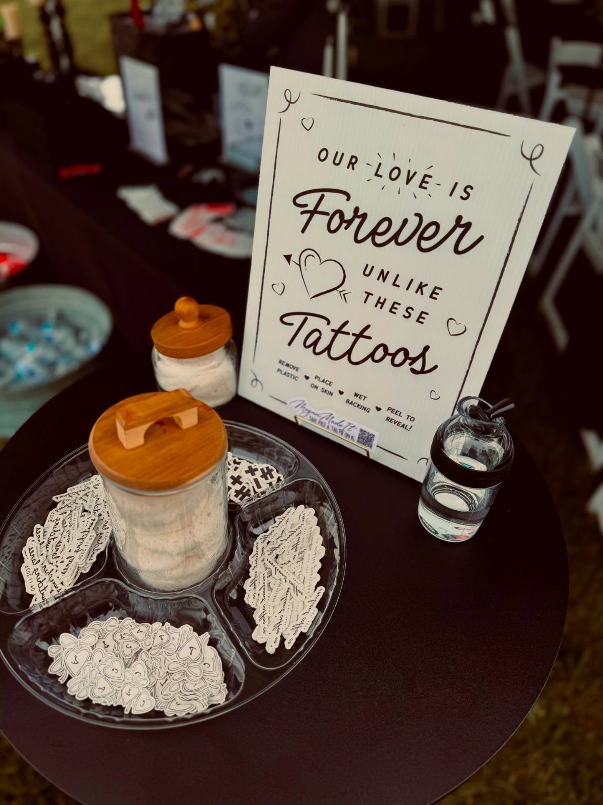 Temporary tattoos in a divided tray next to a wedding favor sign.