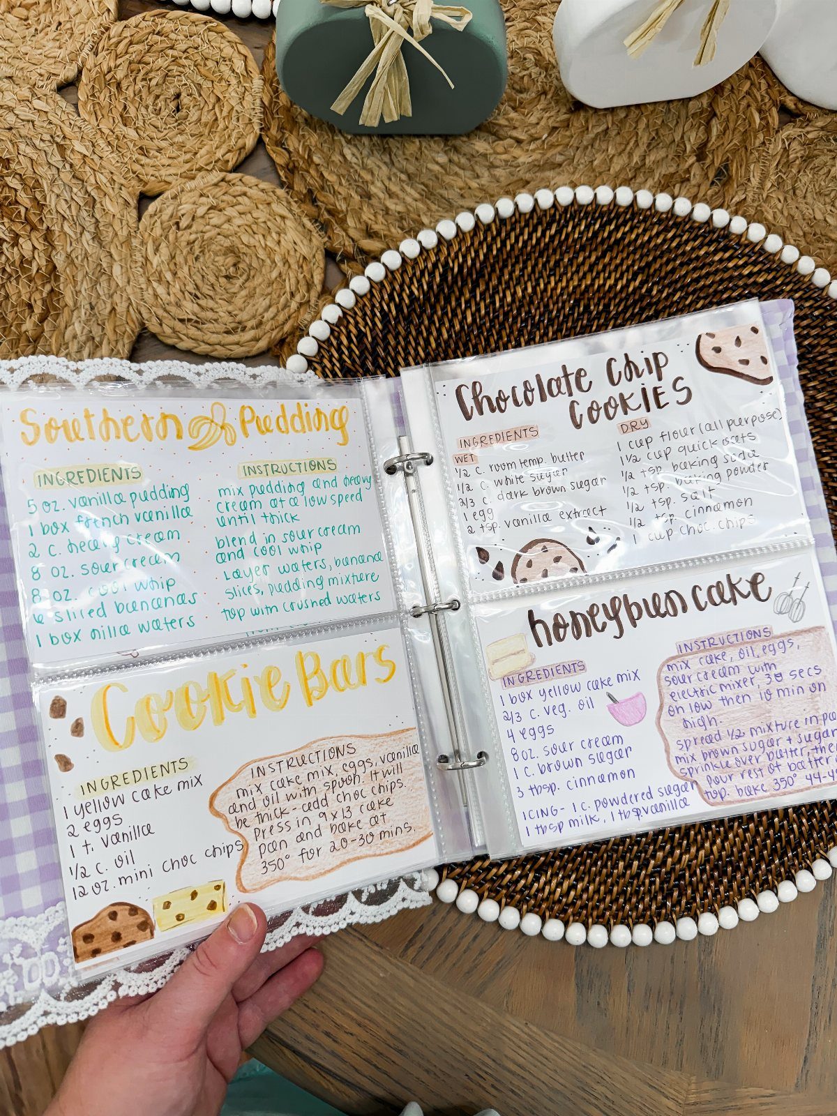 Handwritten recipe cards in a binder featuring desserts on a rustic wooden table