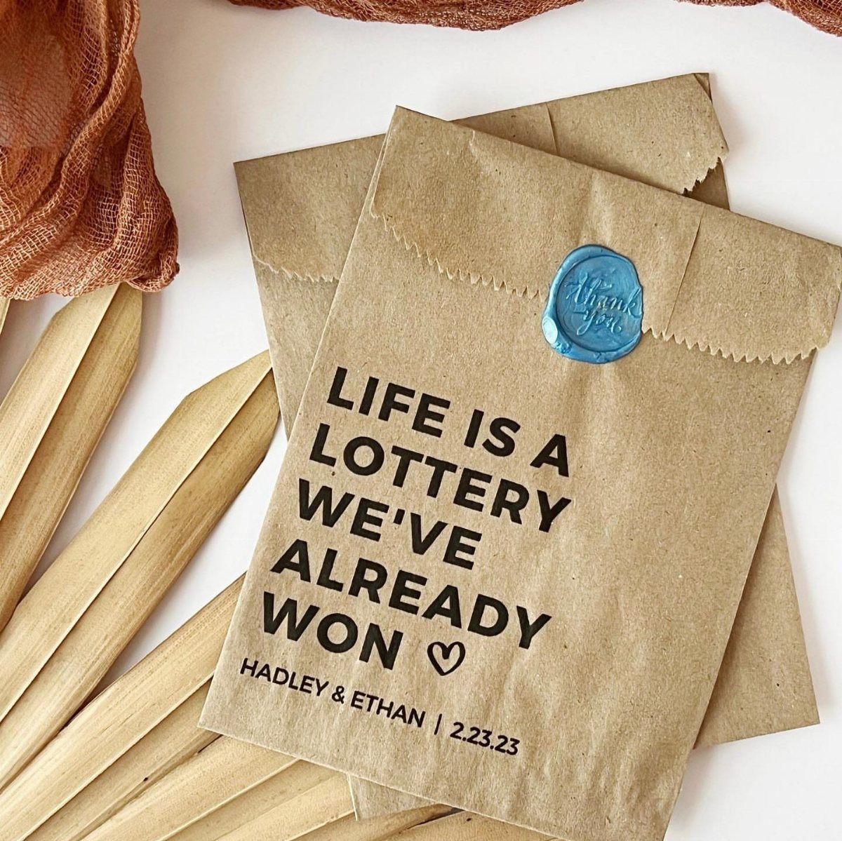 Brown kraft paper wedding favor envelopes with lottery themed text and blue wax seal