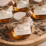 Honey jars with burlap lids and thank you labels on a wooden tray