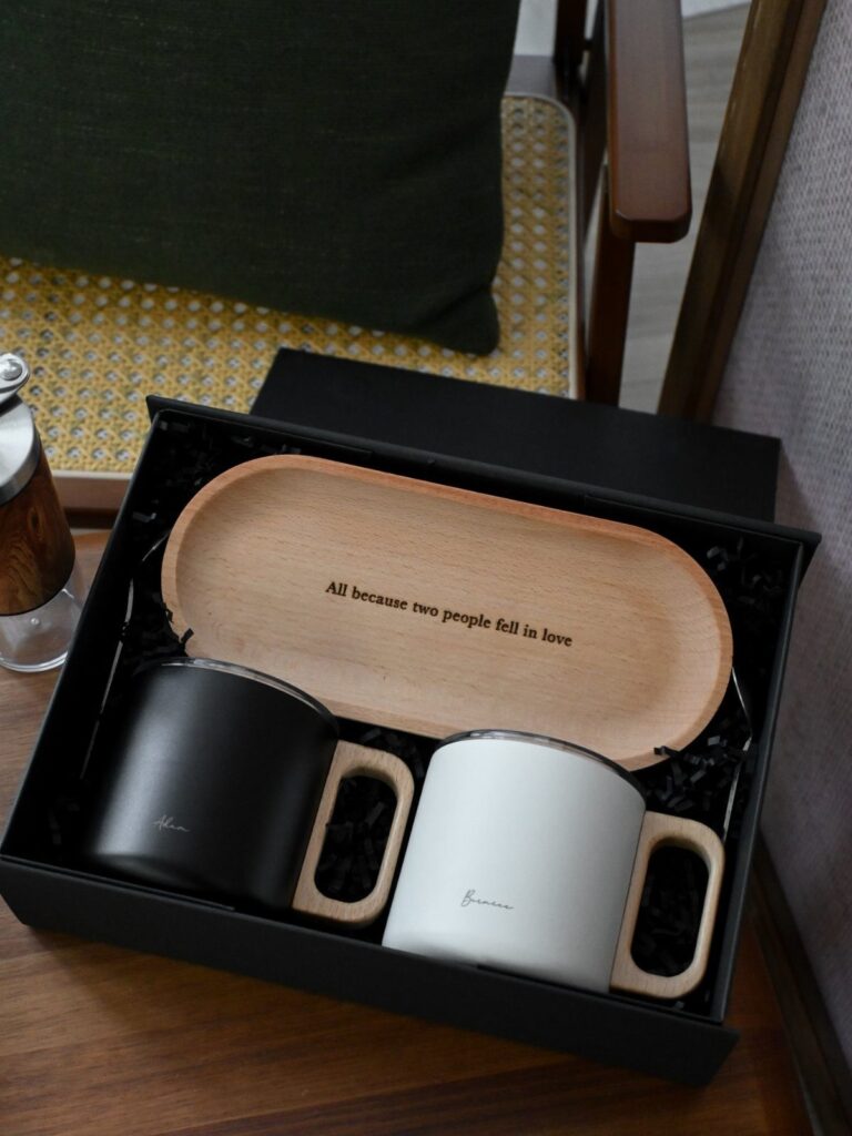 Black and white ceramic mugs with wooden handles in a gift box with tray.