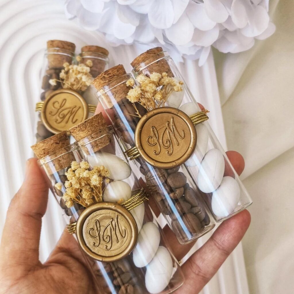 Glass vials filled with chocolate covered almonds decorated with gold wax seals.